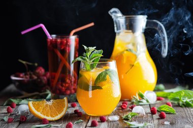 Ahşap arka plan üzerinde turuncu ve ahududu içecekler