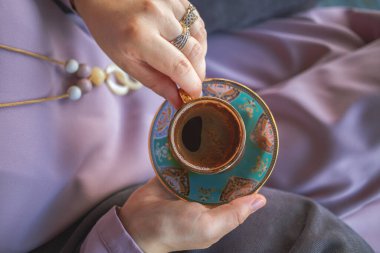 Müslüman kadınların elleri bir fincan geleneksel Türk kahvesi tutuyor
