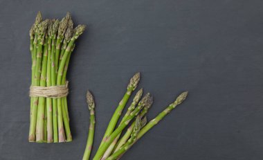 Siyah arka planda taze, yeşil, çiğ kuşkonmaz. Uzayı kopyala Üst görünüm