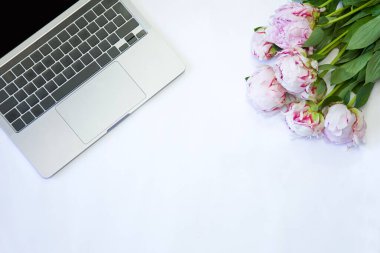 Çalışma masasında bahar çiçeği. Beyaz arka planda şakayık. Kopya alanı olan üst görünüm modeli. Minimum düzlük. Doğum günü. Davet.