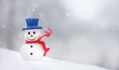 Beyaz karlı arka planda kırmızı eşarplı bir kardan adam. Kış tatili Noel zamanı. Boşluğu kopyala. 
