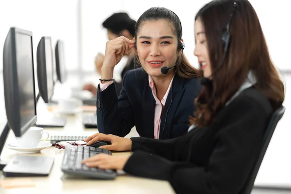在呼叫中心的台式机上与耳机一起工作和交谈的亚洲人快乐的亚洲人微笑呼叫中心商业运营商客户支持团队电话服务 — 图库照片