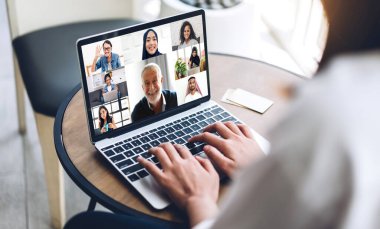 Kadın konuşması, dizüstü bilgisayarın çalışması ve evdeki iş arkadaşlarıyla çevrimiçi video konferansı kullanarak konuşuyor. Yaratıcı kadın, ev konseptinden iş ekibiyle görüntülü konuşma görüşmesi yapıyor.