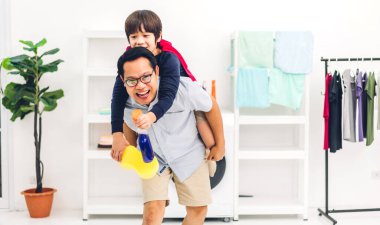 Mutlu bir aşk portresi. Asyalı bir aile babası. Küçük Asyalı bir çocuğu sırtında taşıyor.