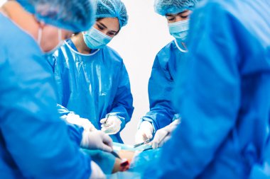 Profesyonel anestezi uzmanı doktor tıp ekibi ve asistanı modern hastane acil servisinde cerrahi ekipmanla jinekolojik ameliyata hazırlanıyor.