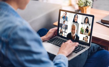 Kadın konuşması, dizüstü bilgisayarın çalışması ve evdeki iş arkadaşlarıyla çevrimiçi video konferansı kullanarak konuşuyor. Yaratıcı kadın, ev konseptinden iş ekibiyle görüntülü konuşma görüşmesi yapıyor.