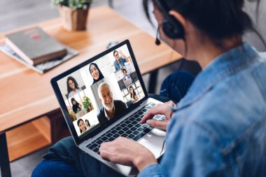 Kadın konuşması, dizüstü bilgisayarın çalışması ve evdeki iş arkadaşlarıyla çevrimiçi video konferansı kullanarak konuşuyor. Yaratıcı kadın, ev konseptinden iş ekibiyle görüntülü konuşma görüşmesi yapıyor.