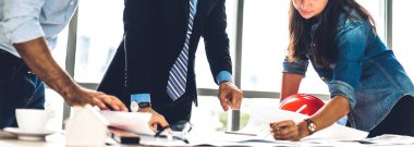 Profesyonel iş toplantıları ve yeni başlangıç projesiyle strateji tartışmaları. Yaratıcı iş adamları modern çalışma ortamında belge raporlarıyla plan yapıyor ve beyin fırtınası yapıyorlar. Takım çalışması kavramı.
