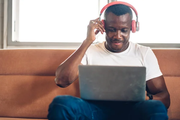 Young black african man relaxing using laptop computer working and video conference meeting at home.Young creative african man talk with headset.work from home concept