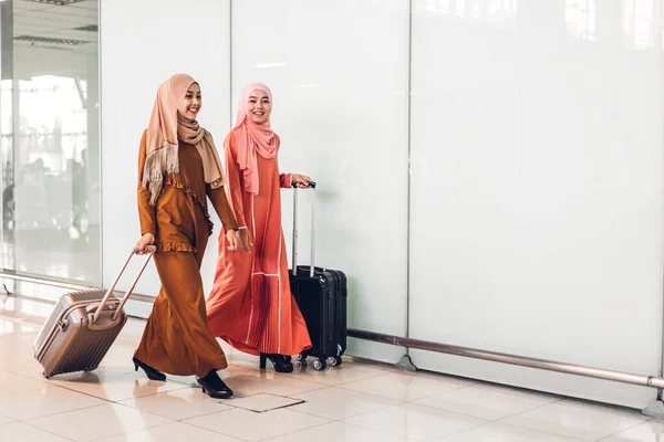 Portrait of happy arabic two friend muslim woman with hijab dress smiling and talking together at store