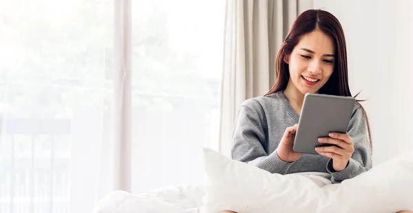 Ευτυχισμένη Γυναίκα Χαλαρώνοντας Χρησιμοποιώντας Tablet Υπολογιστή Στο Κρεβάτι Στο Σπίτι — Φωτογραφία Αρχείου