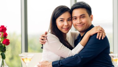 Romantik, genç, mutlu çift rahatlar, sarılır, kutlarız. Lokantadaki kameraya bakın.