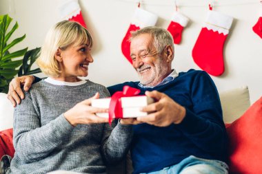Romantik tatlı yaşlı çift sevgililer gününü birlikte kutlarken eğleniyor ve gülümsüyor. Son sınıf öğrencisi, sevgililer gününde evde karısına sürpriz hediye paketi veriyor.