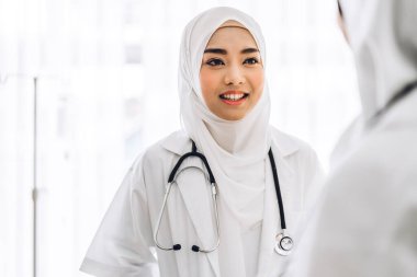 Steteskoplu, üniformalı iki profesyonel tıbbi Müslüman kadın doktor hastanede görüşmeler ve danışmanlık konuşmaları yapıyor.
