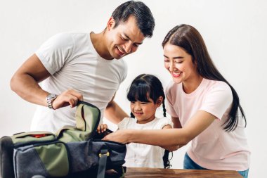 Mutlu Asyalı aile babası ve kızı okula dönmeden önce okul çantalarını kitaplarla dolduruyorlar.