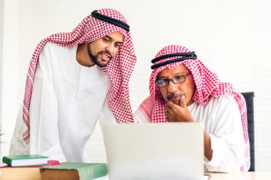 Dizüstü bilgisayarla çalışan iki Arap iş adamının başarısı. Modern ofiste planlama ve beyin fırtınası yapan yaratıcı Arap insanlar. Takım çalışması kavramı.