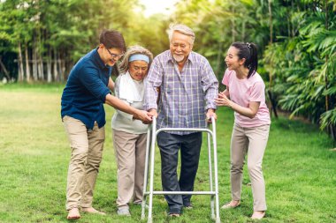 Portre, mutlu, mutlu, gülümseyen, çok nesilli, Asyalı, büyük bir ailenin keyfini çıkarın. Yaşlı, olgun bir baba ve genç, yetişkin bir kadın ve oğlu olan yaşlı bir anne, evde parkta yürüyor. Sigorta kavramı.