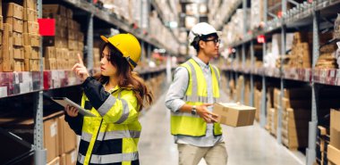 Miğfer mühendisi Asyalı iki mühendis, malzeme ve malzemelerin depo geçmişine sahip raflarda kontrol edilmesi için tablet bilgisayardan talimat verdi. Lojistik ve ticari ihracat