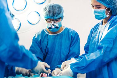 Profesyonel anestezi uzmanı doktor tıp ekibi ve asistanı modern hastane acil servisinde cerrahi ekipmanla jinekolojik ameliyata hazırlanıyor.