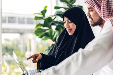 Dizüstü bilgisayarla çalışan iki Arap iş adamının başarısı. Modern ofiste planlama ve beyin fırtınası yapan yaratıcı Arap insanlar. Takım çalışması kavramı.