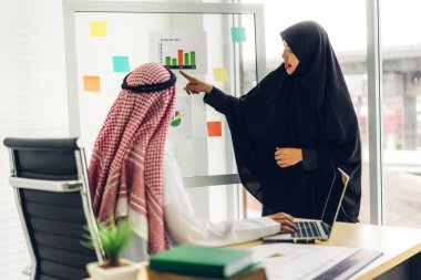 Dizüstü bilgisayarla çalışan iki Arap iş adamının başarısı. Modern ofiste planlama ve beyin fırtınası yapan yaratıcı Arap insanlar. Takım çalışması kavramı.