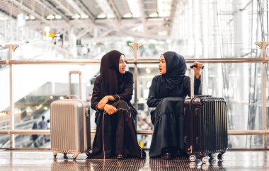 Mutlu Arap iki arkadaş tesettürlü Müslüman kadının portresi mağazada gülümsüyor ve konuşuyor.