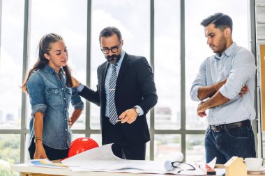 Profesyonel iş toplantıları ve yeni başlangıç projesiyle strateji tartışmaları. Yaratıcı iş adamları modern çalışma ortamında belge raporlarıyla plan yapıyor ve beyin fırtınası yapıyorlar. Takım çalışması kavramı.