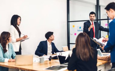 Profesyonel iş sunum toplantısı ve yeni başlangıç projesiyle strateji tartışması. Modern ofiste dizüstü bilgisayarla yaratıcı iş adamları planlama ve beyin fırtınası. Takım çalışması