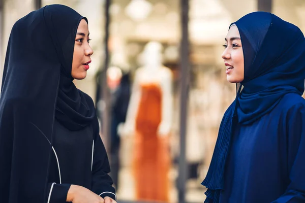 Portrait of happy arabic two friend muslim woman with hijab dress smiling and talking together at store