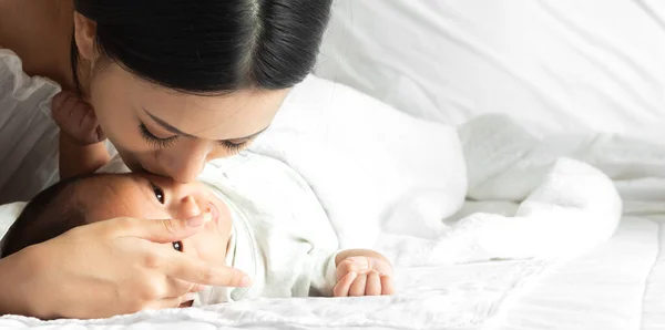 사랑의 Asian 엄마가 스러운 Asian 아기와 즐기는 키스귀여운 침실에서 시간을 — 스톡 사진