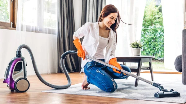 家庭の雑用を行う保護手袋の若いアジアの女性掃除機でほこりを拭く床を掃除し 洗濯掃除機で家を掃除しながら — ストック写真