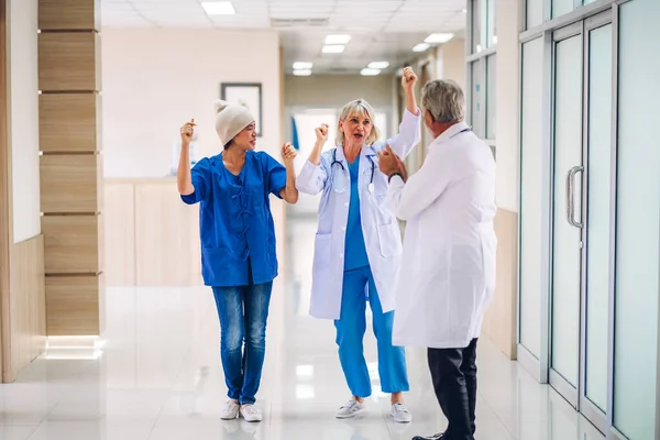 Professional medical doctor team with stethoscope in uniform discussing and dancing with happy patient woman with cancer cover head with headscarf of chemotherapy cancer in hospital.health care