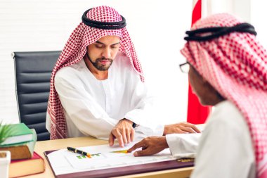 Dizüstü bilgisayarla çalışan iki Arap iş adamının başarısı. Modern ofiste planlama ve beyin fırtınası yapan yaratıcı Arap insanlar. Takım çalışması kavramı.