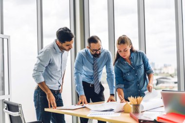 Profesyonel iş toplantıları ve yeni başlangıç projesiyle strateji tartışmaları. Yaratıcı iş adamları modern çalışma ortamında belge raporlarıyla plan yapıyor ve beyin fırtınası yapıyorlar. Takım çalışması kavramı.