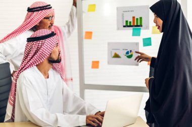 Üniversiteli Arap iş adamlarının dizüstü bilgisayar ve belge raporlarıyla çalışmalarının başarısı. Yaratıcı Arap iş adamları yeni bir başlangıç projesi projesiyle buluşup strateji analizi planlıyorlar.