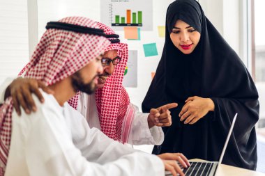 Üniversiteli Arap iş adamlarının dizüstü bilgisayar ve belge raporlarıyla çalışmalarının başarısı. Yaratıcı Arap iş adamları yeni bir başlangıç projesi projesiyle buluşup strateji analizi planlıyorlar.