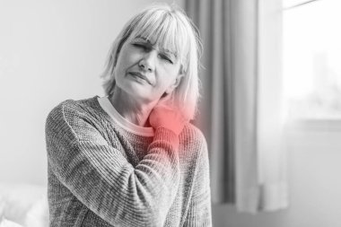 Boynuna dokunan yaşlı hasta kadınların omuz ve boynu ağrıyor. Sağlık ve ilaç konsepti.