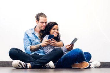 İki arkadaş rahatlayın. Akıllı telefon ve tablet bilgisayar teknolojisini birlikte kullanın ve sosyal uygulamaları kontrol edin. İletişim konsepti.