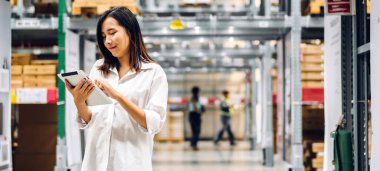 Depo 'daki ürün ve gereçlerin kontrol edilmesi için tablet bilgisayarında çalışan kadın portresi. Lojistik ve ticari ihracat.
