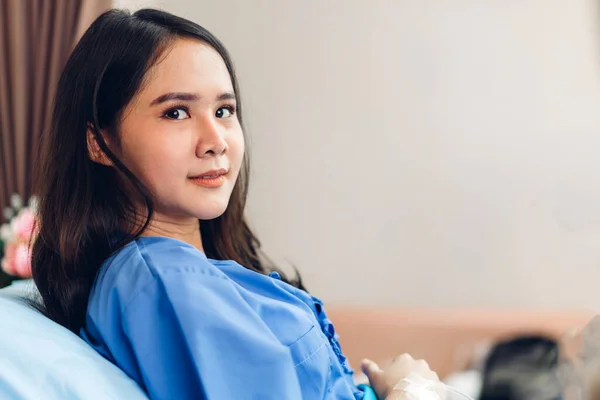 Portrait of smiling asian woman patient sitting on bed looking at camera with health medical care express trust and Insurance concept in room at hospital