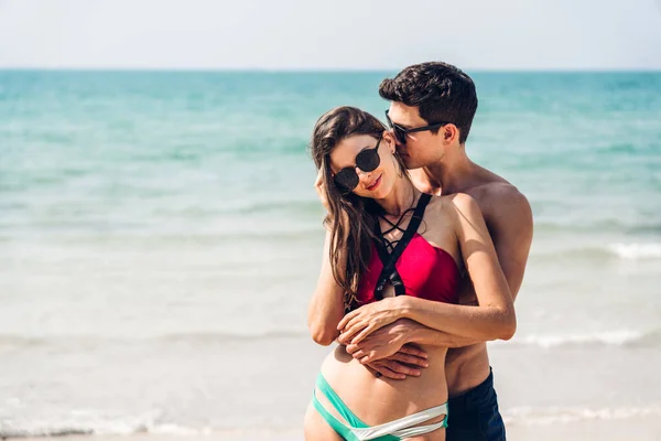 休暇ロマンチックな恋人若い幸せなカップル抱擁と海で砂の上に立って楽しいと熱帯のビーチで一緒にリラックスしています 夏の旅行 — ストック写真