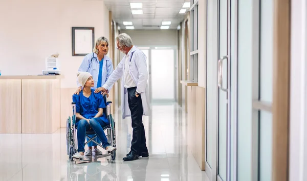 Professional medical doctor team with stethoscope in uniform discussing with patient woman with cancer cover head with headscarf of chemotherapy cancer in hospital.health care concept