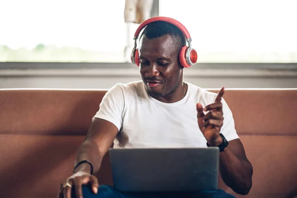 Young black african man relaxing using laptop computer working and video conference meeting at home.Young creative african man talk with headset.work from home concept