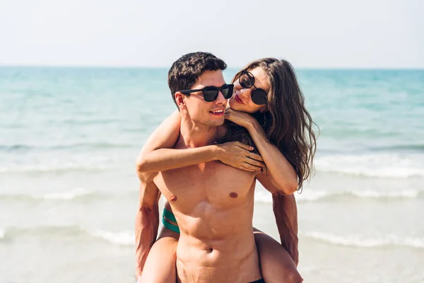 休暇ロマンチックな恋人若い幸せなカップル抱擁と海で砂の上に立って楽しいと熱帯のビーチで一緒にリラックスしています 夏の旅行 — ストック写真