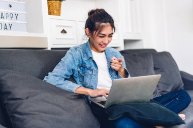 Genç gülümseyen Asyalı kadın bilgisayarlı bilgisayar kullanma ve evdeki iş arkadaşlarıyla çevrimiçi görüntülü görüşme teknolojisi kullanıyor. Genç yaratıcı kız iş ekibiyle video görüşmesi. Evden çalışma.