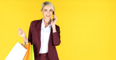 Kredi kartlarıyla alışveriş yapan güzel kadınların portresi ve sarı arka planda alışveriş yapmak.