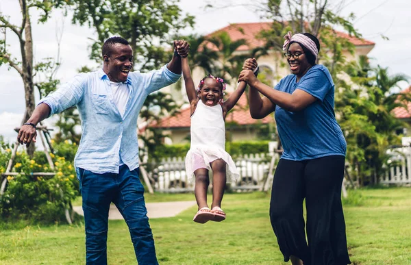 Portrait of enjoy happy love black family african american father and mother with little african girl child smiling and play having fun moments good time in summer park at home