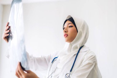 Müslüman Asyalı kadın doktor röntgen fotoğrafına bakıyor. Sağlık ve tıp.