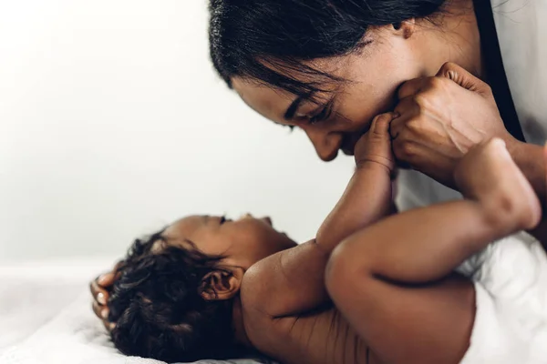 幸せな愛の家族の肖像画アフリカ系アメリカ人の母親は愛らしい小さなアフリカ系アメリカ人の赤ちゃんと遊んでいます お母さんは白い寝室で楽しい時間をかわいい息子の瞬間に触れて 黒人家族の愛 — ストック写真