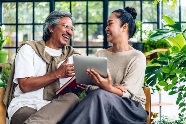 Üst düzey Asyalı çift tablet bilgisayarlarını birlikte kullanırken iyi vakit geçiriyor. Mutlu yaşlı karı koca sosyal medyayı kontrol ediyor, haberleri okuyor ya da evde otururken internetten alışveriş yapıyor.